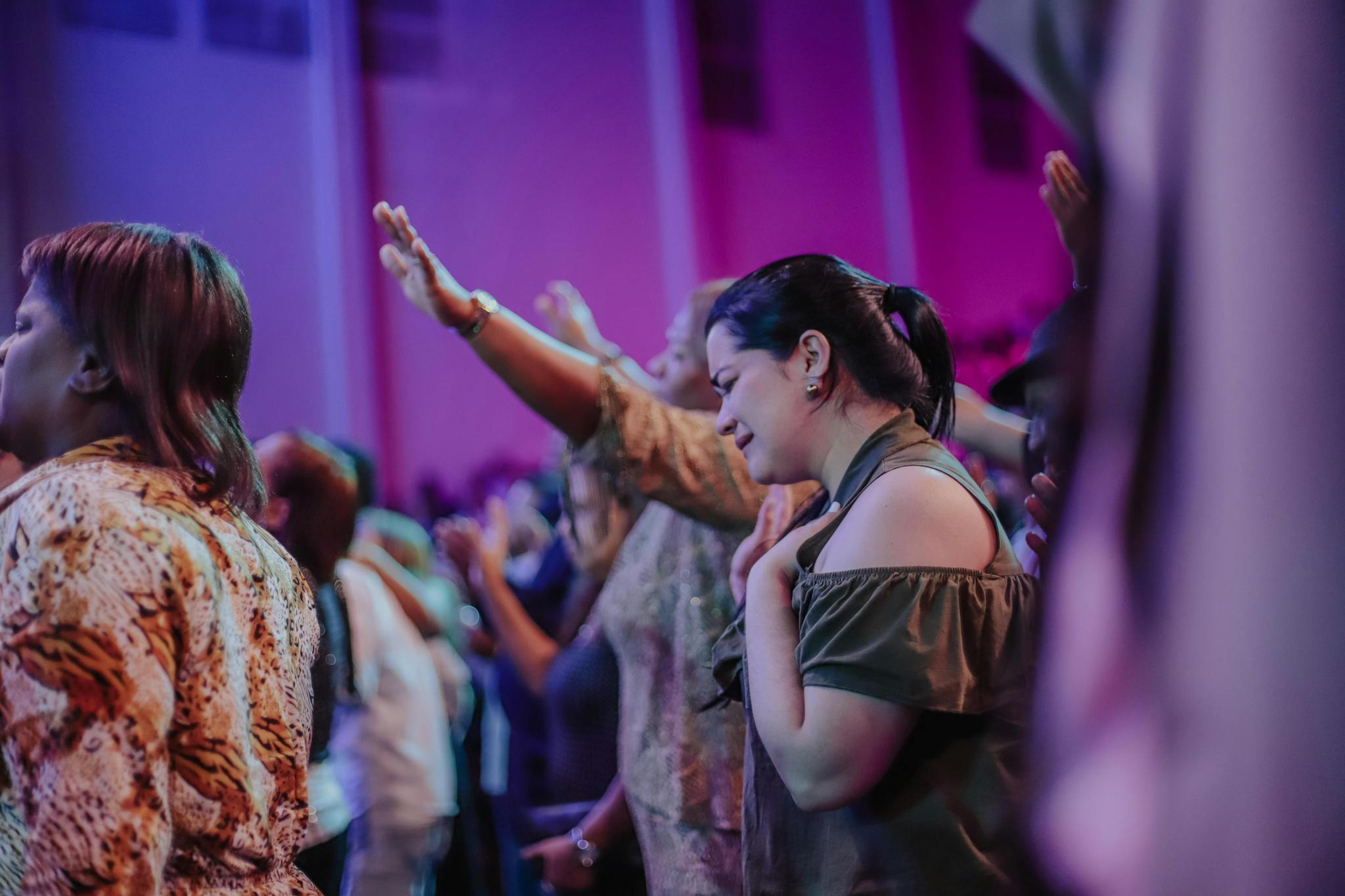 A diverse group of adults engaged in a spiritual worship gathering with uplifting ambiance.